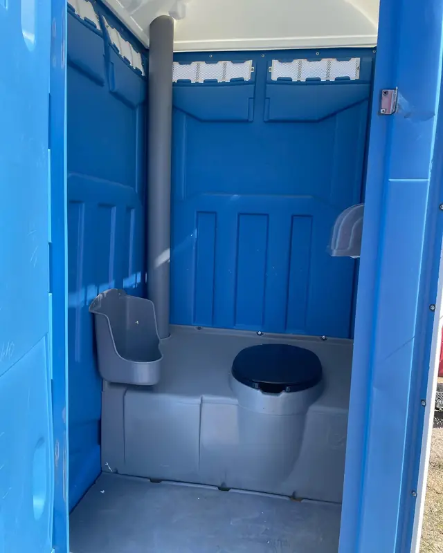 Inside a blue standard porta potty