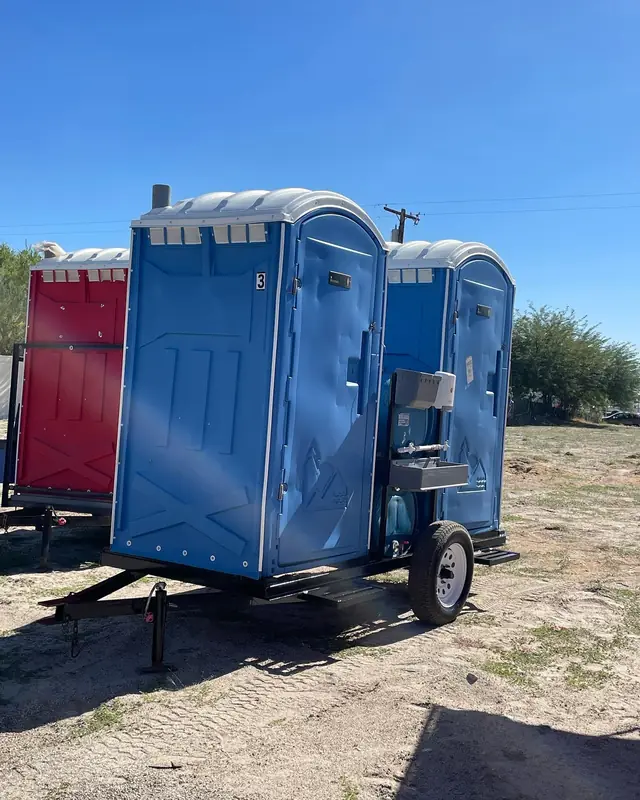 Porta potties on a towable trailer in a field